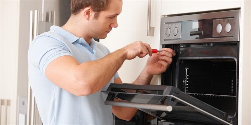 Técnico reparando un horno.